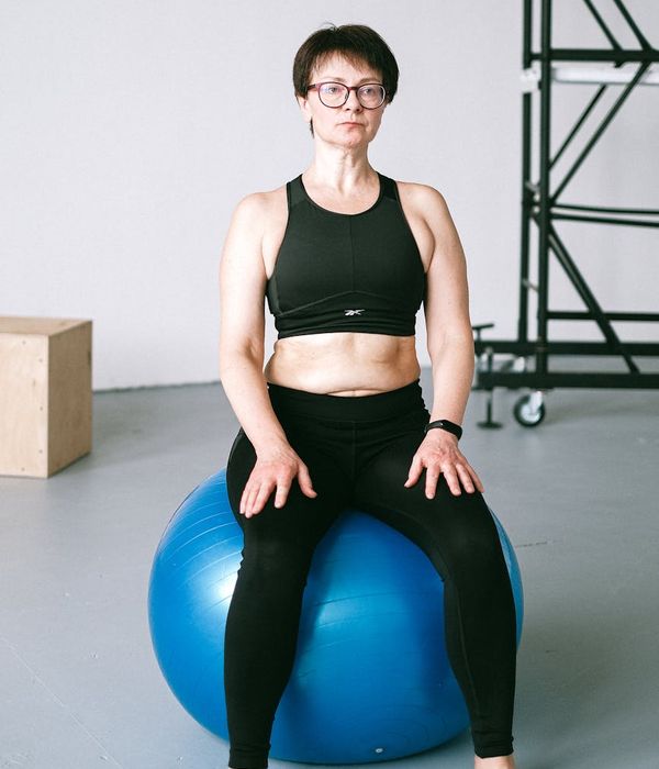 Athletic man performing stability exercises in a dark modern gym environment.